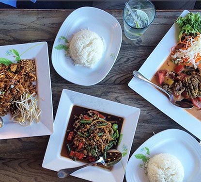 A variety of Asian entrees on a wooden table