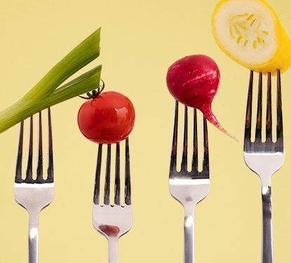 Four forks pointing upwards with a vegetable on each one