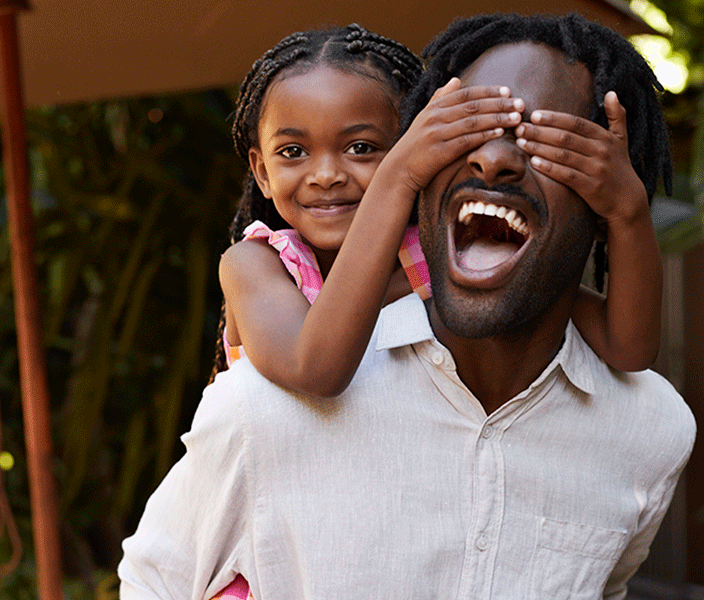 A daughter sitting on dad's shoulders