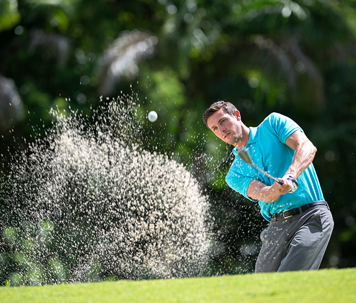 A man in stylish golf-wear golfing