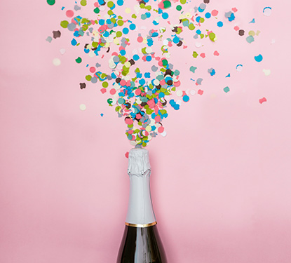 A champagne bottle popping out confetti