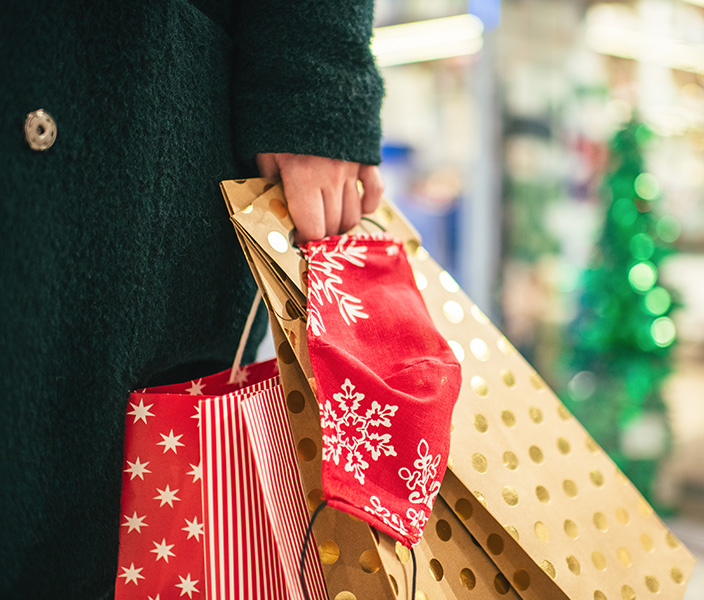 A shopper holding festive holiday shopping bags