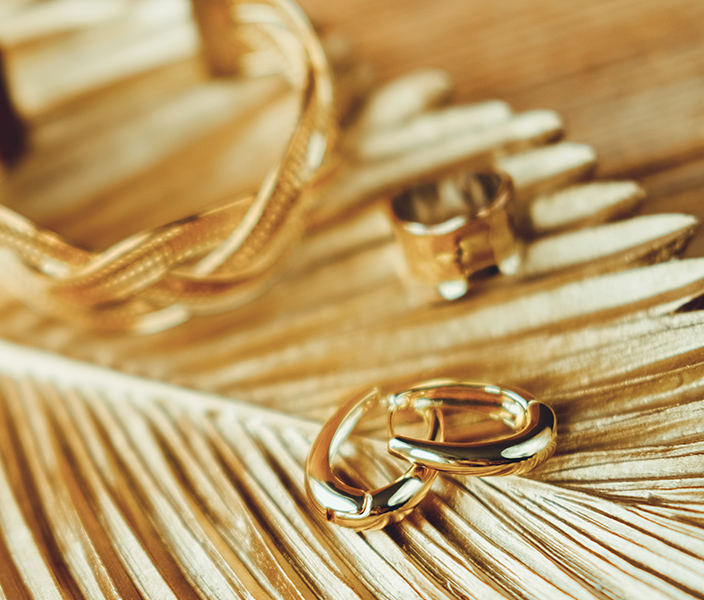 Gold jewelry on a gold palm frond