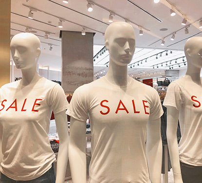 Three mannequins wearing t-shirts that say "Sale"