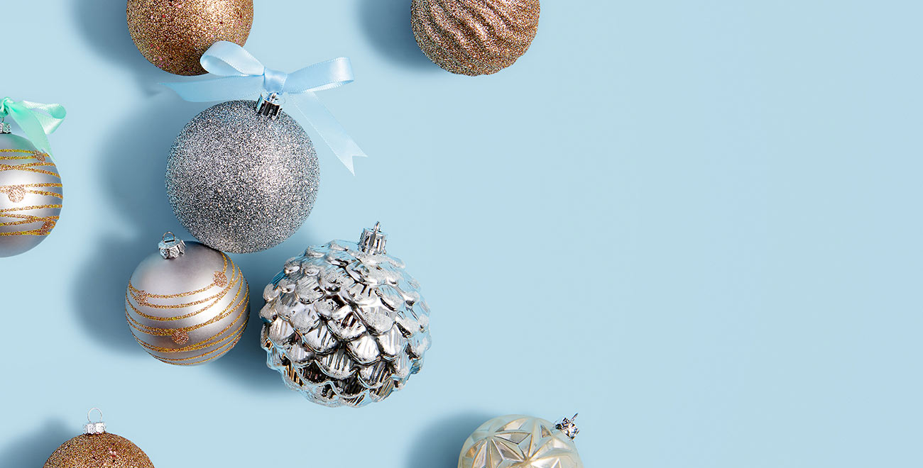 Metallic holiday ornaments on a blue background
