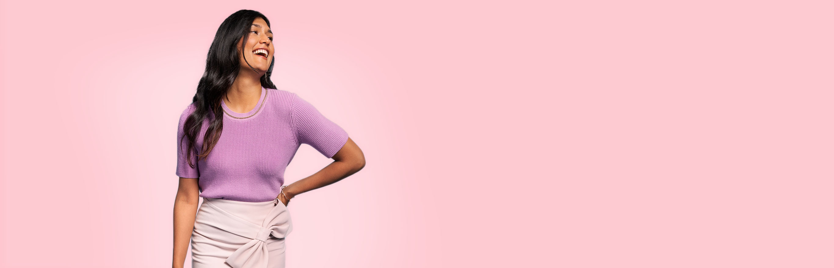 A woman in a purple spring top and wrap skirt