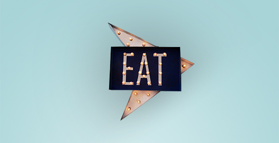 An illuminated sign that says "Eat" with an arrow