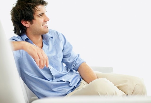 young man sitting on sofa smiling