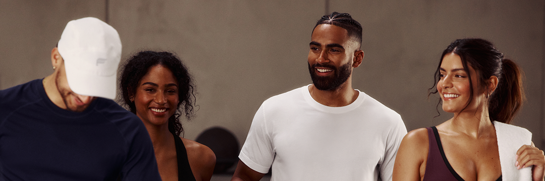Diverse group of adults in activewear smiling and socializing in a fitness studio