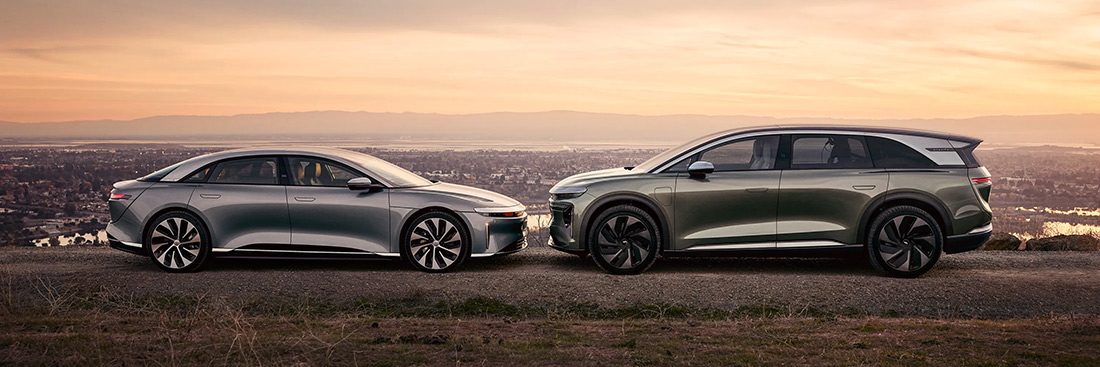 A Lucid sedan and SUV parked at a scenic overlook